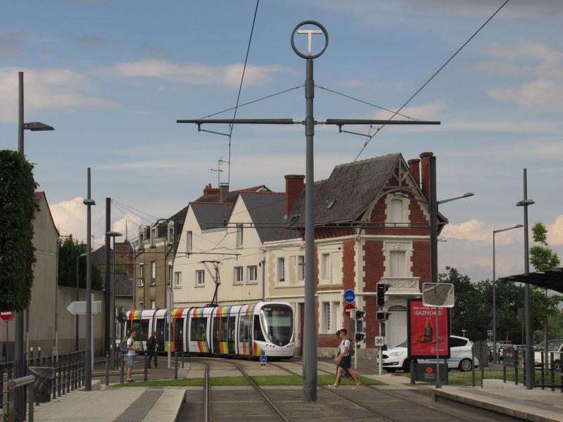 Detail sloupu trolejového vedení, který v zastávkách nese výrazný zdálky viditelný znak tramvaje. Mimo centrum až na jednu výjimku o kousek dál na severu tramvaje jezdí normálnì pod trolejemi.