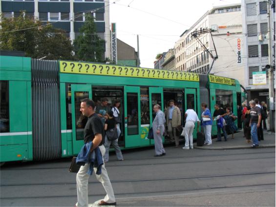 Zastávka linky 8 pøímo uprostøed køižovatky aneb nic není nemožné. Odpolední špièka vrcholí a lidé vystupují z nejnovìjšího typu tramvaje v Basileji. Stále tu však mùžete vidìt i letité tramvajové staøenky.