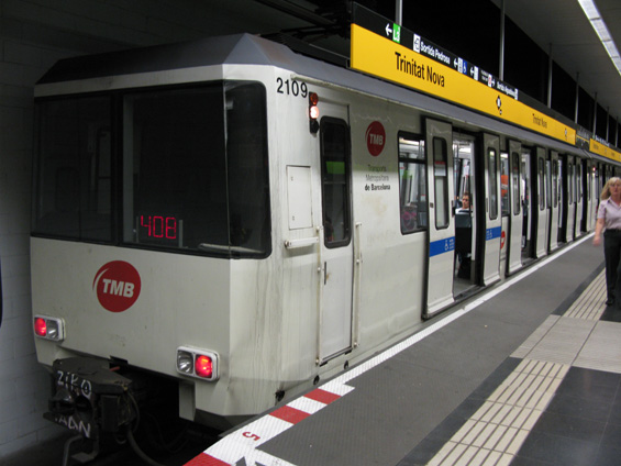 Starší typ barcelonského metra s dveømi na klièku. Ve stanici Trinitat Nova se na jednom nástupišti setkává žlutá linka L4 s krátkou zelenou linkou L11. První dveøe soupravy jsou urèeny pro vozíèkáøe, protože právì u tìchto dveøí je ve všech stanicích zvýšena hrana nástupištì pro bezproblémový pøejezd z nástupištì do vozu.