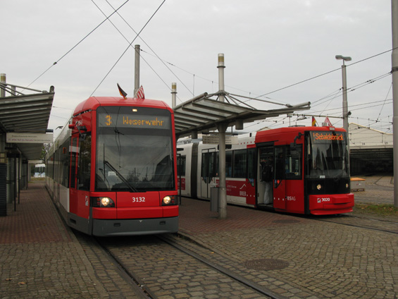 Setkání nového a staršího typu brémských tramvají na koneèné Gröpelingen, jež je zároveò vozovnou. Novìjší typ vlevo je o 35 cm širší než typ GT8N vpravo - kvùli tomu musela být èást tratí pøestavìna. Nový typ tramvaje si také díky své šíøce umí "nadjet" nad nástupní hranu, nástup je tak velmi pohodlný.