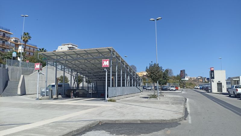 Vstup do stanice metra Milo západnì od pùvodní Koneèné Borgo. Najdete zde velké záchytné parkovištì a kolem jezdí také úzkokolejka okolo Etny. Vedlejší mezilehlá stanice Cibali byla otevøena teprve v roce 2021.