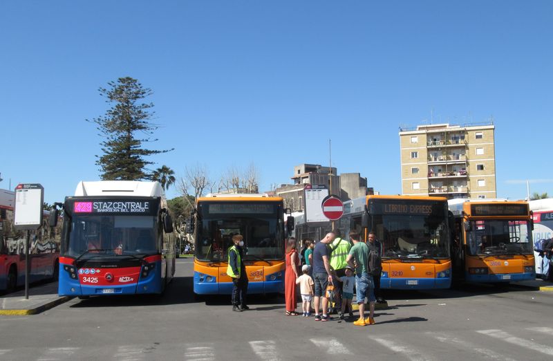 Mìstské autobusy pøed hlavním vlakovým nádražím. MHD tu provozuje dopravní podnik AMTS, starší autobusy jsou oranžovomodré, novìjší èervenomodré. Pøevažují tu italské autobusy Bredamenarinibus.