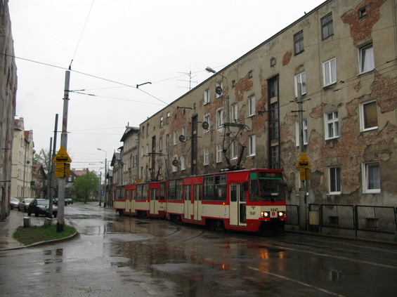 Konstal pøijíždí zanedbanou zástavbou v uplakaném poèasí do vozovny Nowy Port na severu Gdaòsku. Zajímavostí, kterou najdete v nástupní zastávce, jsou zveøejnìné odjezdy všech tramvají vyjíždìjících z vozovny na pravidelné linky.