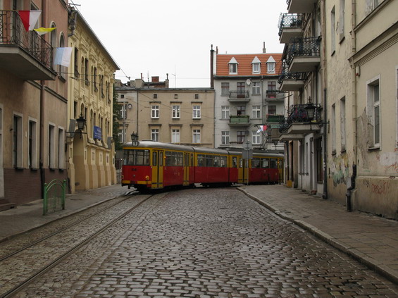 Krefeldská tramvaj se proplétá historickým centrem Grudziadzi po jednokolejce.