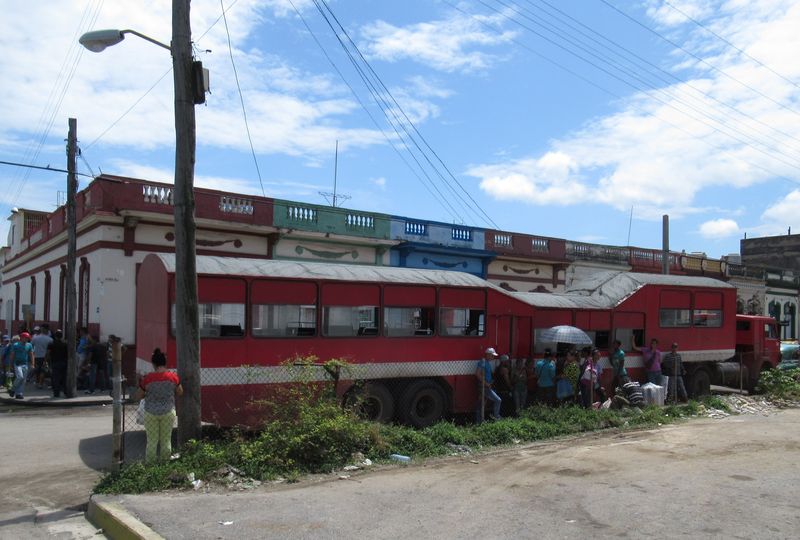 Cestující vyèkávají na odpolední odjezd tohoto èásteènì nízkopodlažního „velblouda“ poblíž autobusového nádraží v Cienfuegos. Tyto návìsy mìly rùznou délku i uspoøádání dveøí a interiéru, ty nejvìtší pojaly až 300 lidí.