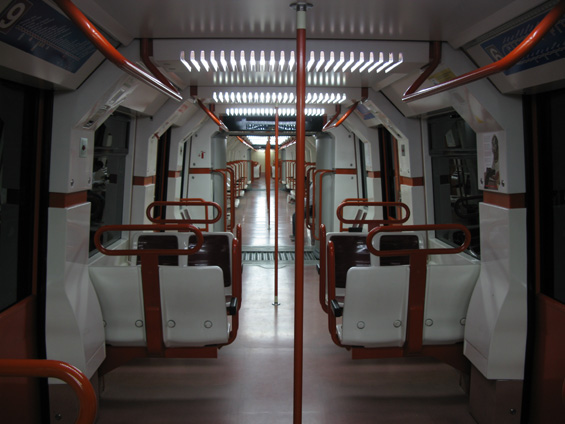 Interiér starší soupravy metra. Pøíènì uspoøádané sedaèky jsou tu výjimkou. Naopak pravidlem jsou plastové sedaèky a možnost prùchodu mezi vozy.