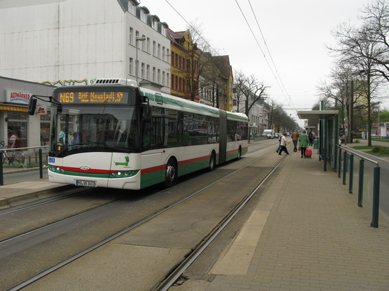 Další pøíklad pøestupu hrana-hrana mezi tramvajemi a autobusy. Staèí jen obèas pustit autobus na koleje. Z této zastávky odjíždí autobus do více smìrù, proto jsou jednotlivé smìry odlišeny ještì písmenem pøed èíslem linky. I když nejsou autobusy v Magdeburgu díky rozsálé tramvajové síti pøíliš významné, na nìkterých linkách se mùžete svézt kloubovými autobusy. Ty vìtšinou zajiš�ují tangenciální smìry nebo obsluhují nìkterá paneláková sídlištì.