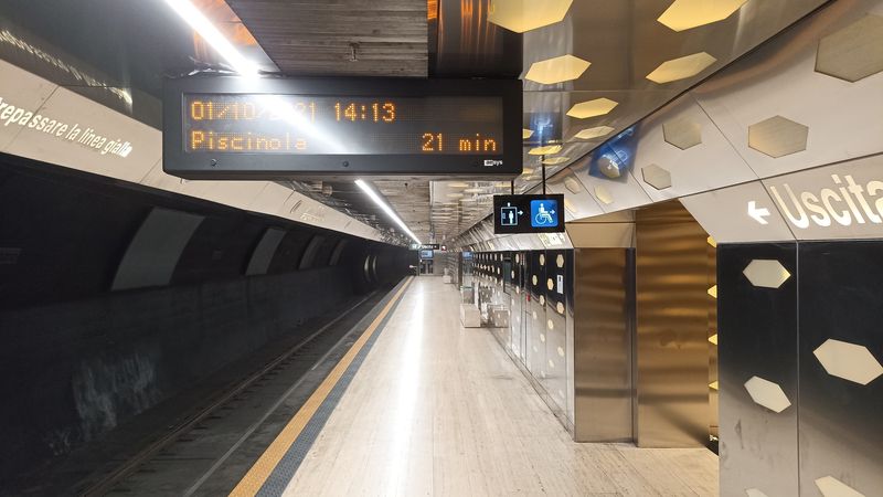 Nástupištì nejnovìjší stanice metra Duomo a panel hlásající další odjezd na zaèátku odpolední špièky za krásných 21 minut. Dopravce na svých webových stránkách uvádí prùmìrný interval žluté linky metra 14 minut.