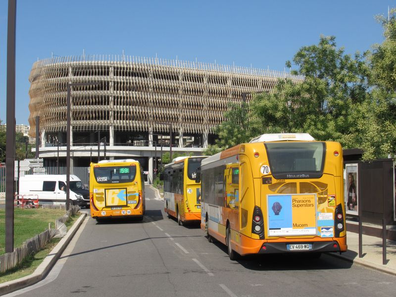 Mìstské i pøímìstské autobusy Iveco a Heuliez v místních barvách na koneèné CADAM, kde také konèí tramvajová linka 2, resp. její polovina, která nejede na letištì. V pozadí je velké záchytné parkovištì.