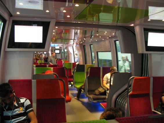 Barevný interiér nových jednotek pro rychlou pøímìstskou železnici Transilien. Výrobcem je spoleènost Bombardier. Vlaky mají ještì širší skøíò než jejich pøedchùdci díky kratším èlánkùm.