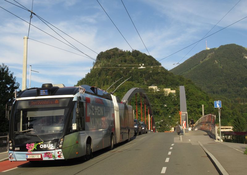 Metrostylebus v reklamním polepu pøejíždí po novém mostì pøes železnièní tra� na lince 2 ve smìru z východní koneèné Obergnigl.