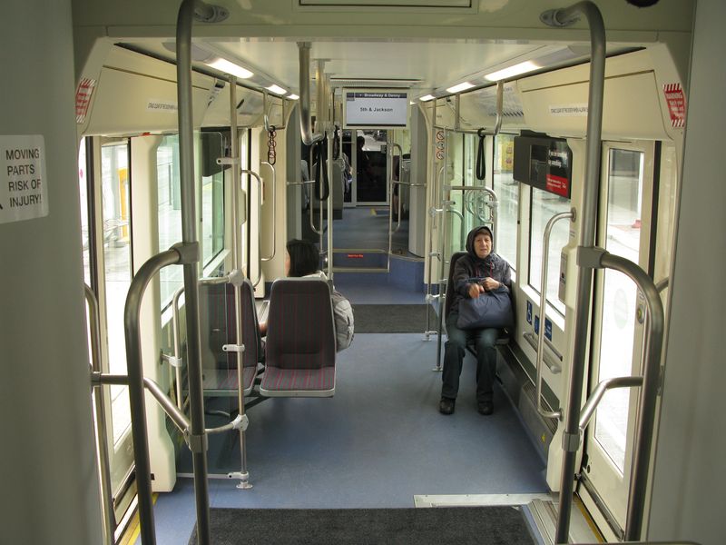 Interiér tøíèlánkové obousmìrné tramvaje Inekon pro linku First Hill preferuje prostor pro koèárky, kola èi invalidní vozíky na úkor sedaèek. Tramvaj má také bateriový pohon, který umožòuje jízdu jižním smìrem (z kopce) bez trolejí.