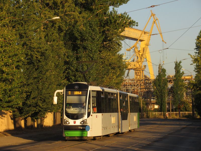 Jednosmìrná verze tramvaje Moderus Beta, které tu jezdí 4 a dodány byly v letech 2014 a 2018. Linka 11 jede spolu s linkou 6 z centra na sever do smyèky Stocznia Remontowa. V pozadí ramena jeøábù místních lodìnic a kontejnerových pøekladiš�.